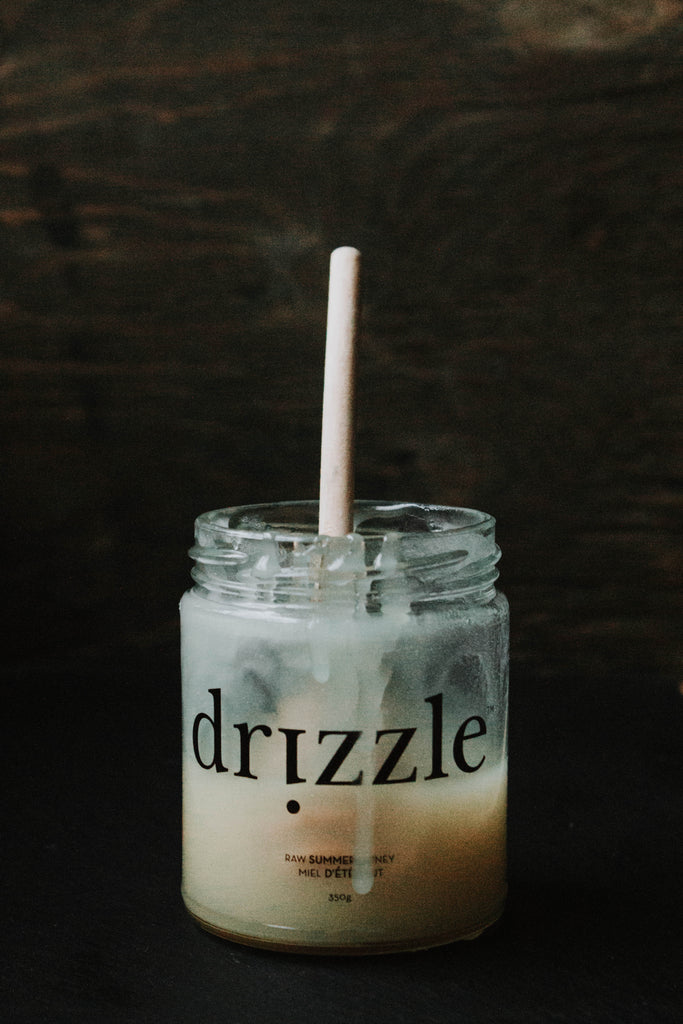 Drizzle Summer honey in a glass jar with a honey dipper