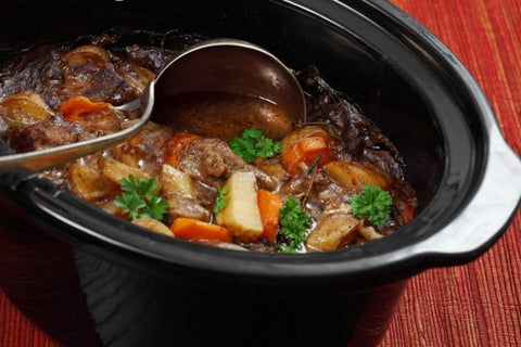 slow-cooked beef stew in a black crockpot