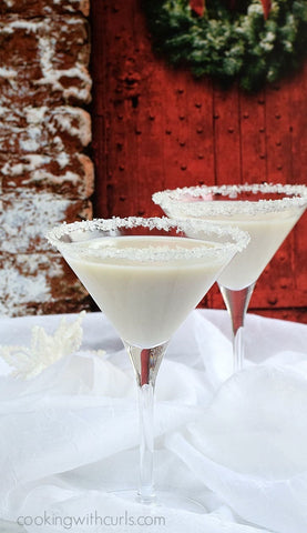 snowflake martinis sitting on top of a table of snow