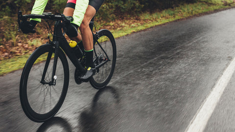 A cyclist riding a bike in the rain