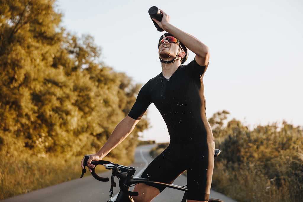 man drinking water mid bike ride