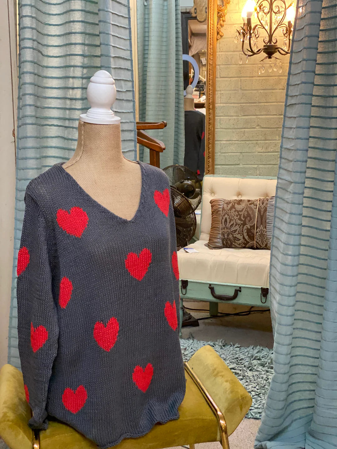 grey knitted sweater with red hearts on a mannequin