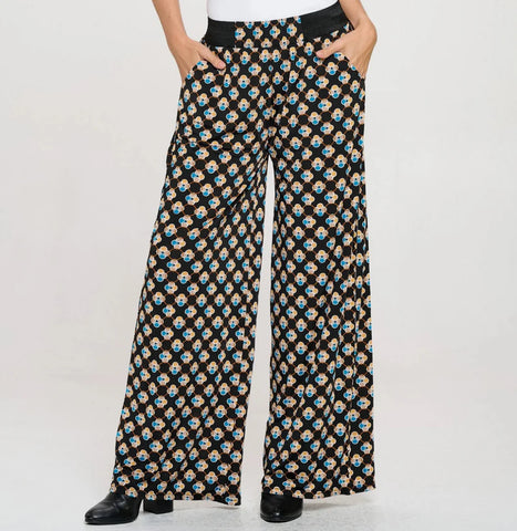 A studio model in patterned flowy pants
