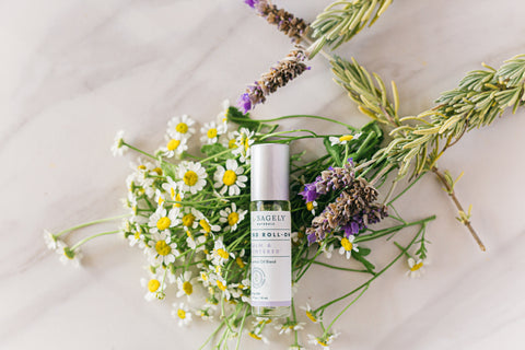 Sagely Naturals Calm & Centered CBD Roll-On lying on top of chamomile and lavender