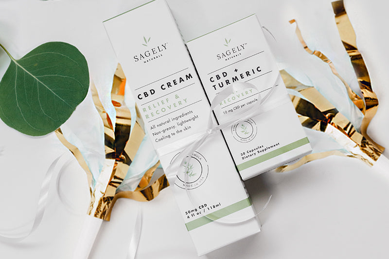 The Sagely Naturals Relief & Recovery CBD cream and CBD capsules sitting on top of exciting gold confetti celebrating Sagely Natural's 4th birthday.