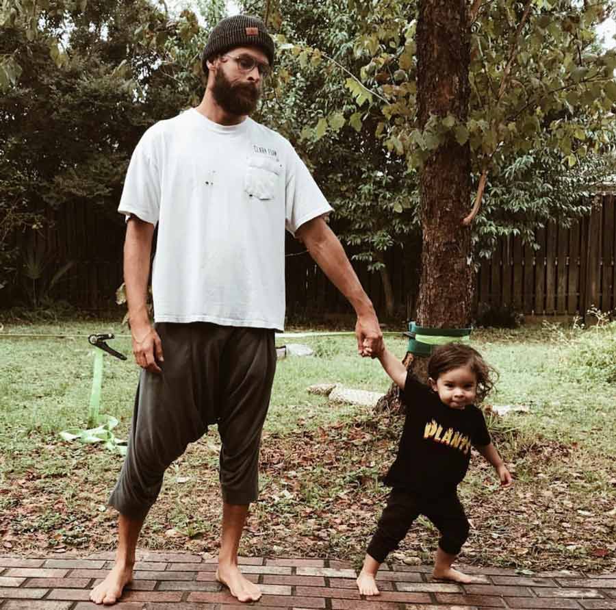 Sterling Spencer holding his son's hand outside.