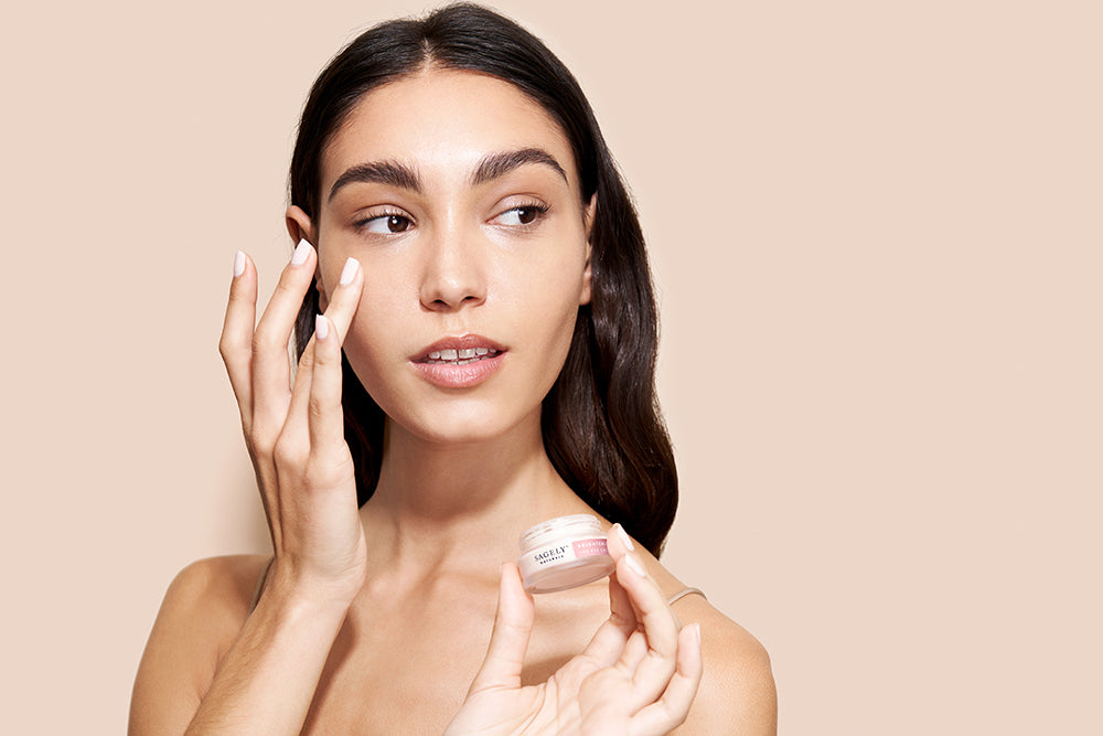 A woman gently applying Sagely Naturals CBD Eye Cream to her skin