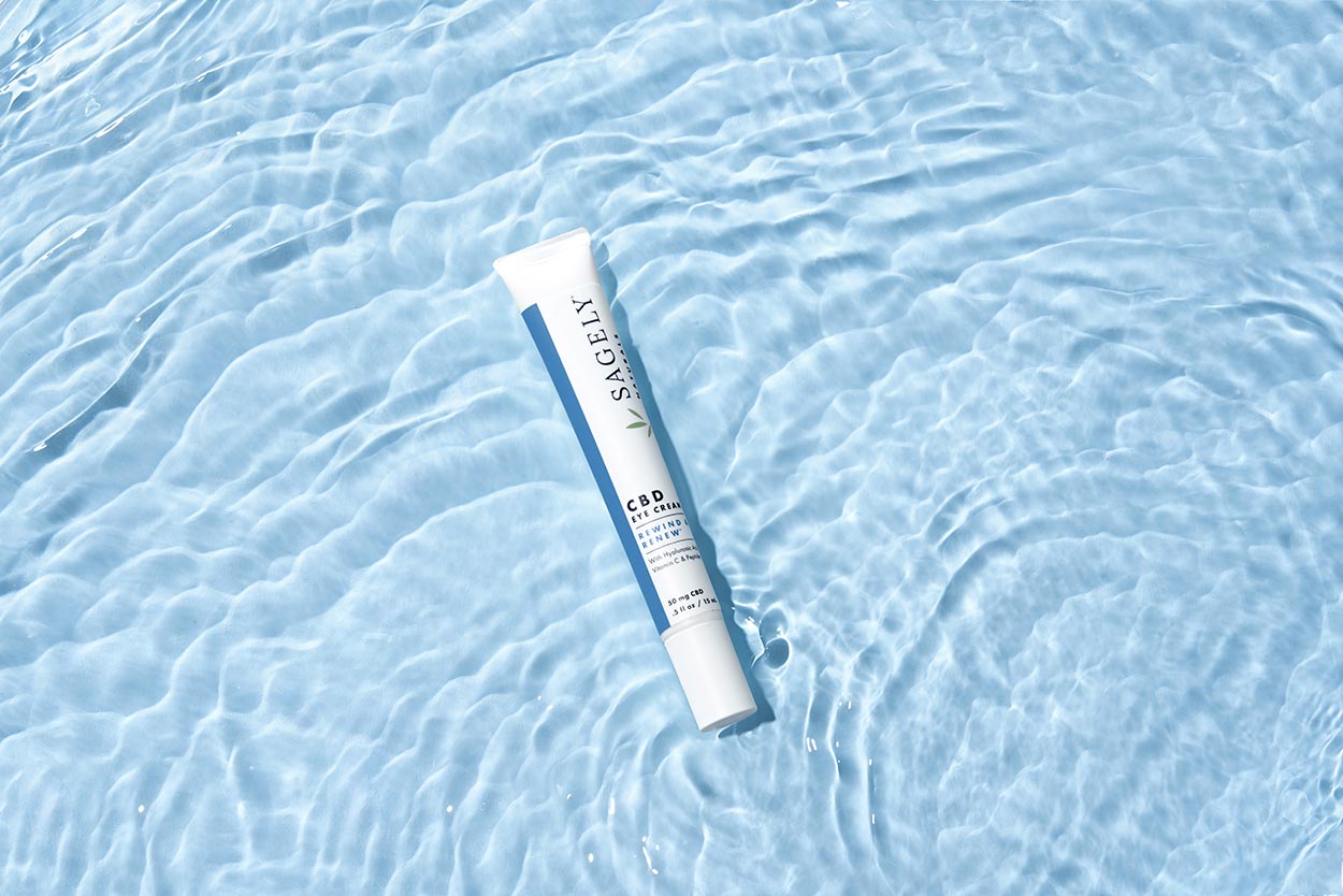 Sagely Natural's new CBD skincare eye cream, pictured brightly on light blue water. 