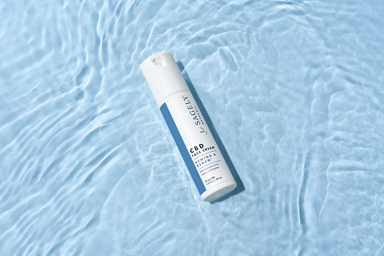 Sagely Natural's new CBD skincare face cream, pictured brightly on light blue water. 