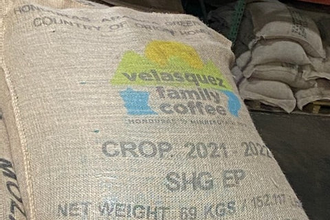 Burlap sack of Velasquez Family Coffee with colorful VFC logo