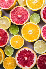 citrus fruits cut in half and facing up - grapefruit, oranges, limes, lemons
