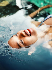 woman lying in water with face upward