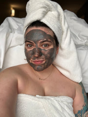 woman with charcoal mask on her face