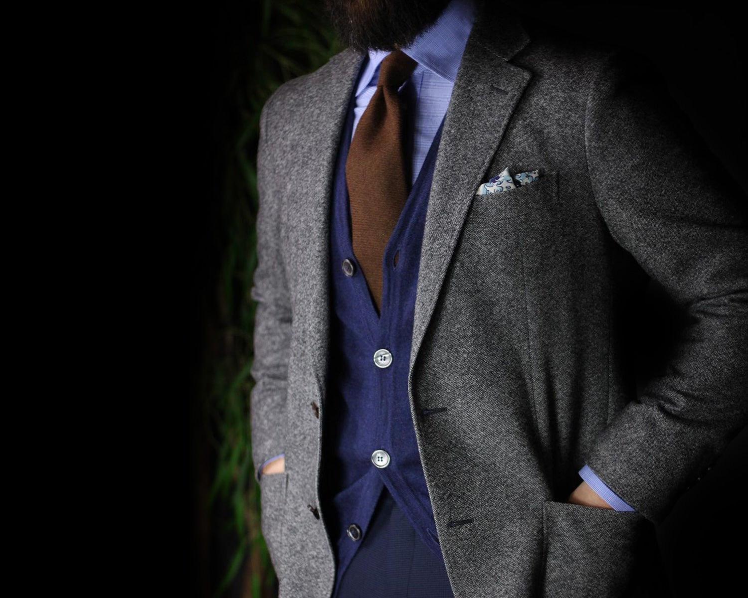 Light grey blazer with blue vest and trousers paired with brown tie.