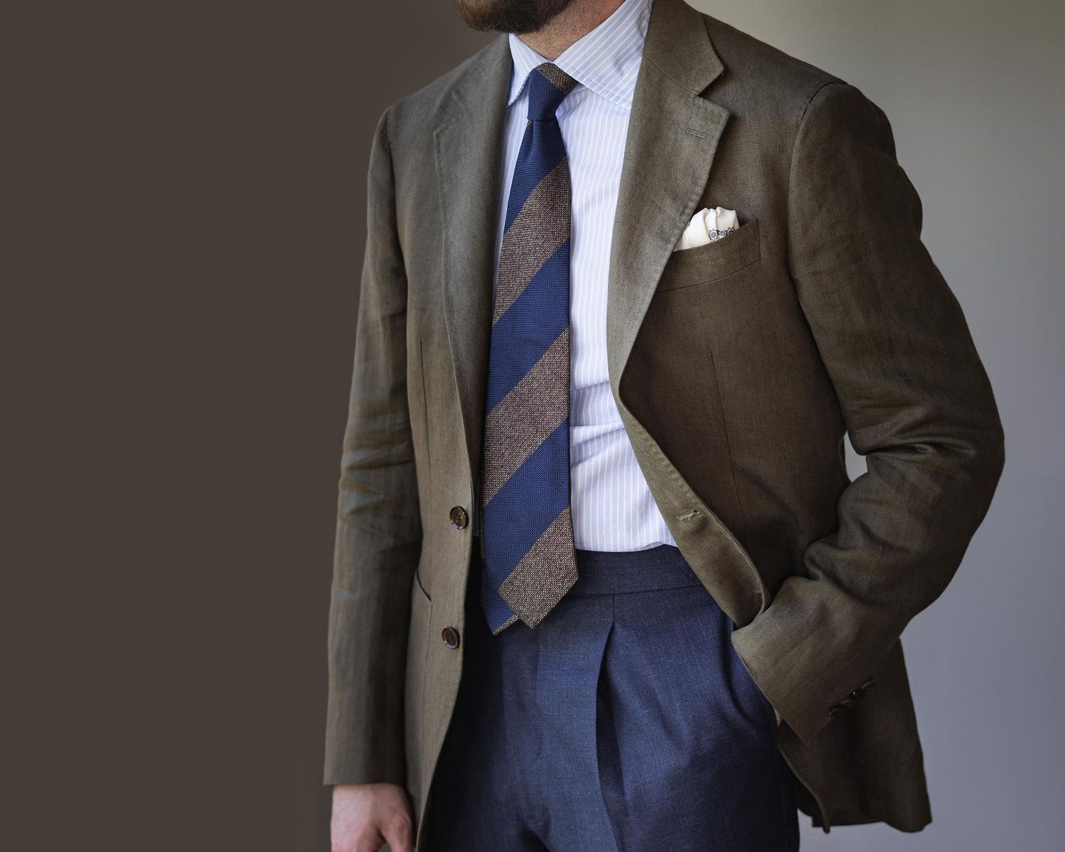 Blazer with blue trousers and light brown and blue grenadine block tie