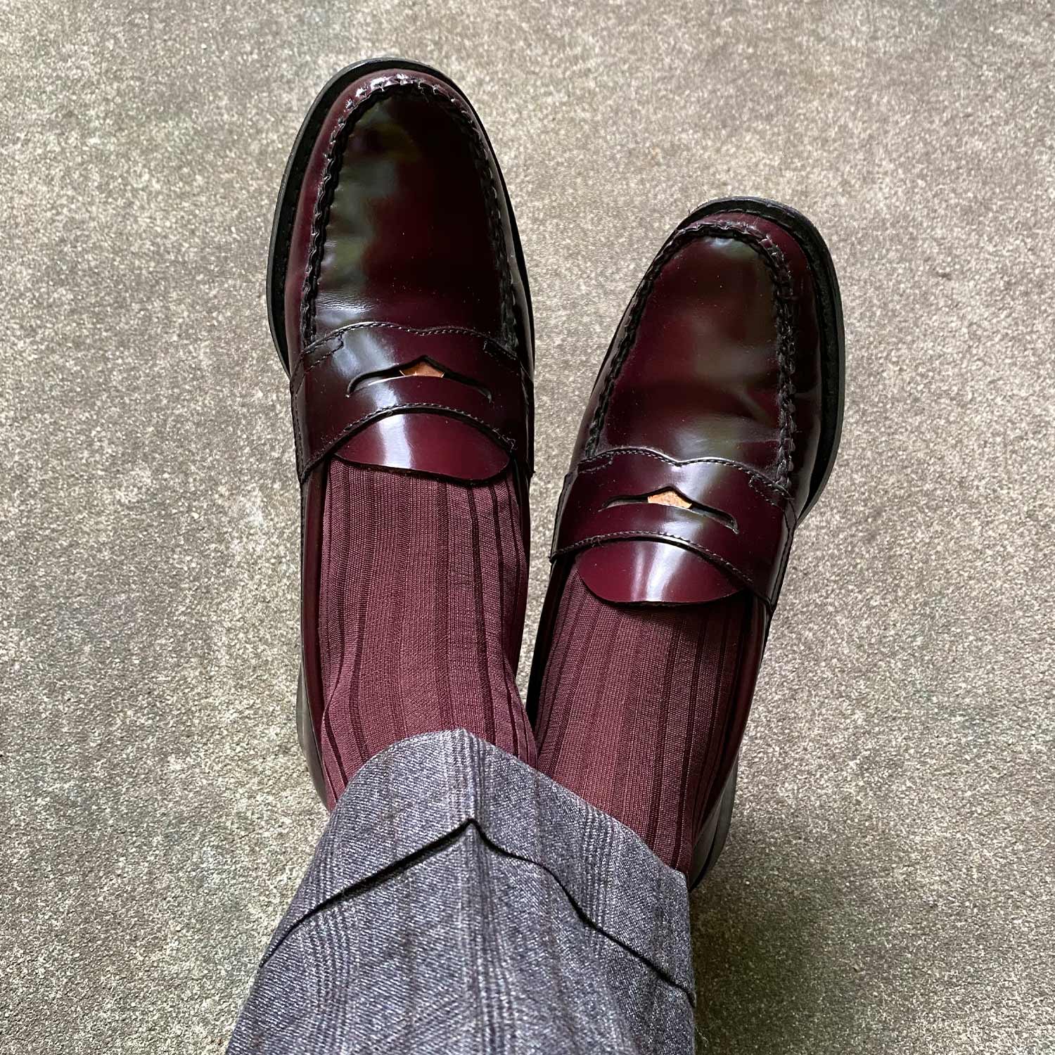 Burgundy socks pair with burgundy loafers and grey pants