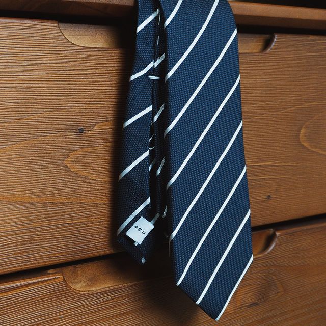 Aklasu White Striped Deep Blue Six-Fold hanging in a wooden cabinet.