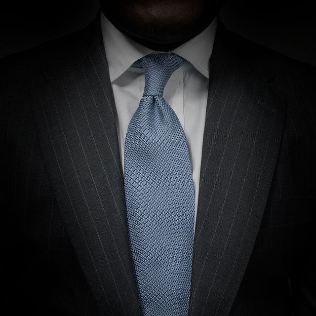Aklasu Sky Blue Grenadine Tie worn with a white shirt and grey suit.