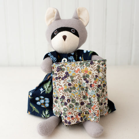 gwendolyn raccoon holding floral fabric