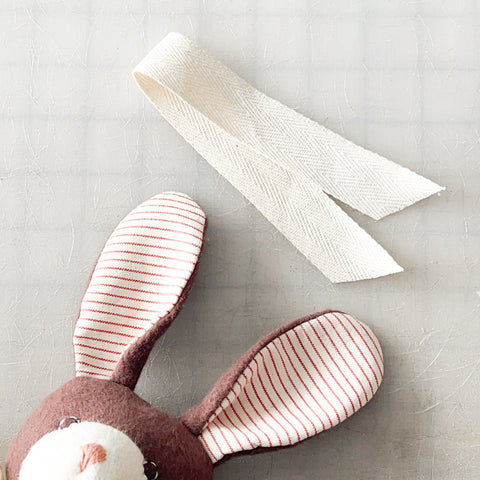 Zoe Rabbit next to a piece of ribbon trimmed for the sash