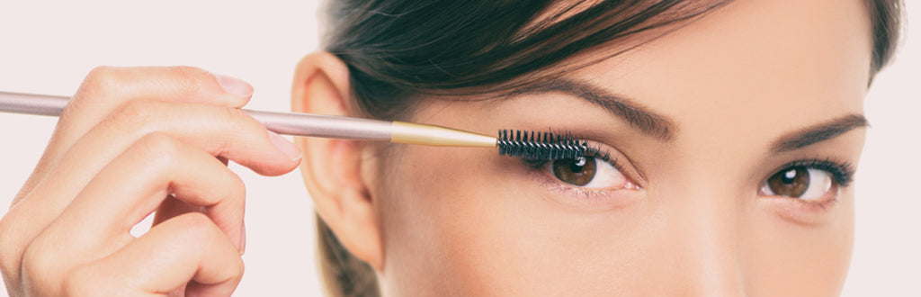 women applying castor oil on her eyelashes