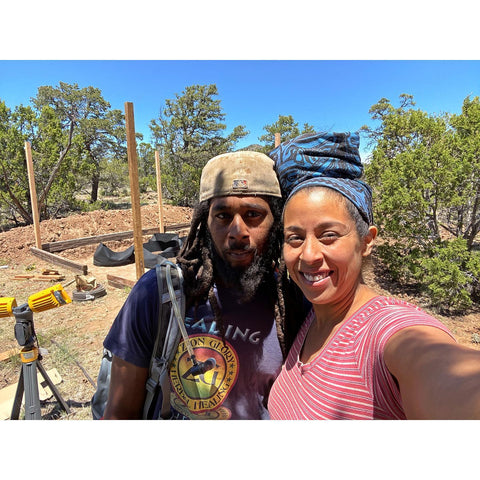 Brown man and woman standing in the forest