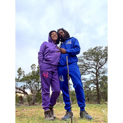 Brown man and woman standing in the forest with sweat suits