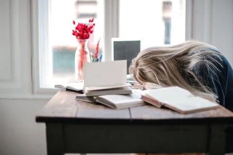  Woman falling asleep on the desk after a stressful evening of w