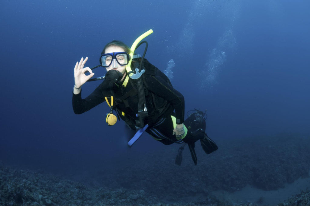 A female diver giving the OK sign