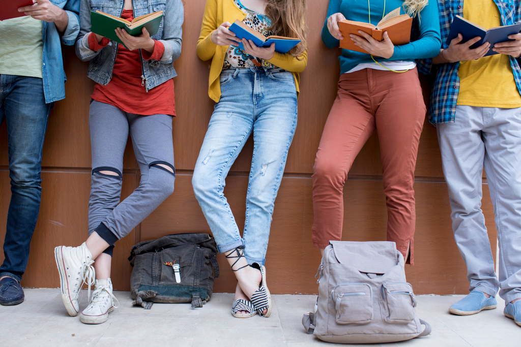 a group of teenage girls reading books