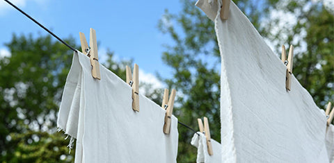 White laundry hanging outside with laundry clips