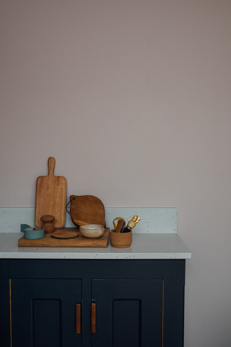 a blue kitchen unit with chopping boards and pots