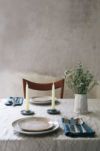 rustic table laid with cream plates and blue napkins