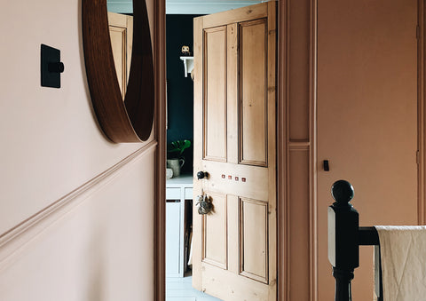 A pink hallway and a wooden door