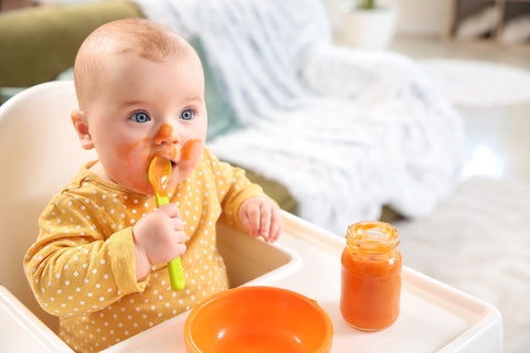 baby has food stains on clothes from eating at table with no bib