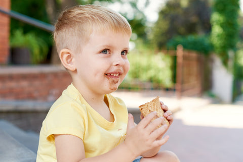 child with chocolate stains on shirt from eating ice-cream