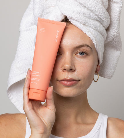 Women holding skincare product up to her face. SoWhippy Prebiotic Cream cleanser