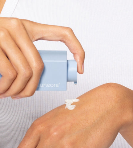 Woman pumping daily ultra-hydrating serum onto hand for evening skincare routine.