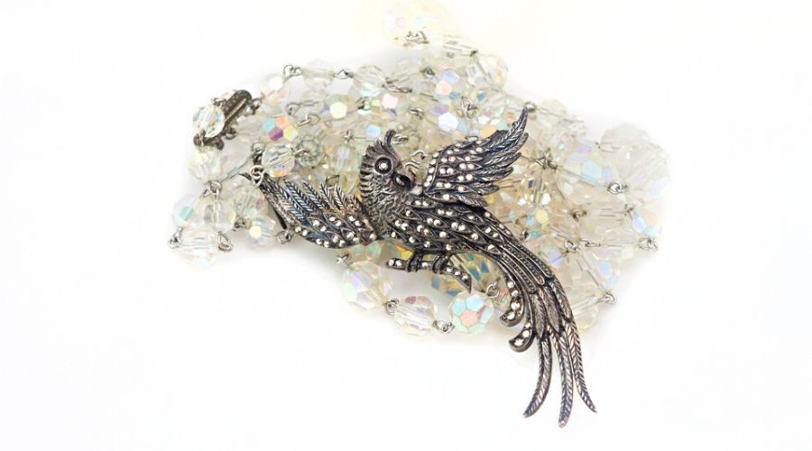 A vintage silver marcasite brooch and crystal beads isolated on white background