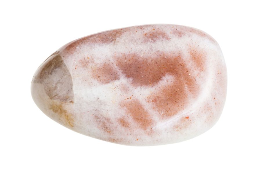 Closeup of pink moonstone on a white background.