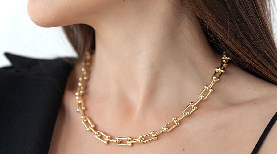 a beautiful woman wearing a modern gold hardware design necklace