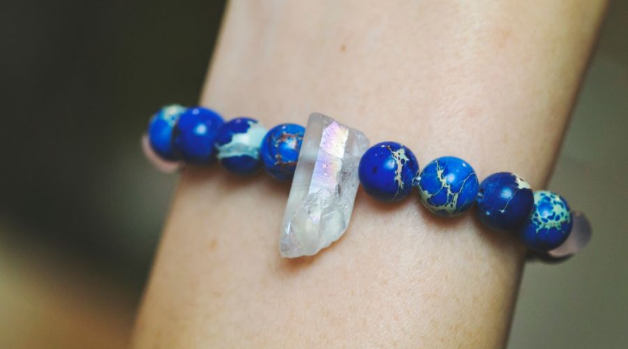 a bracelet made from blue jasper beads with a crystal as the centerpiece