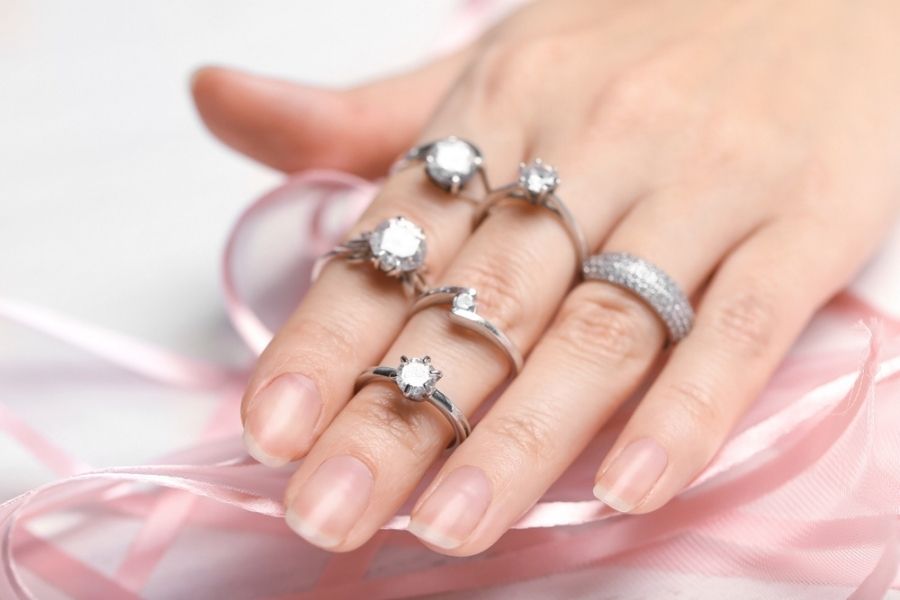 a variety of platinum diamond rings on a womans hand