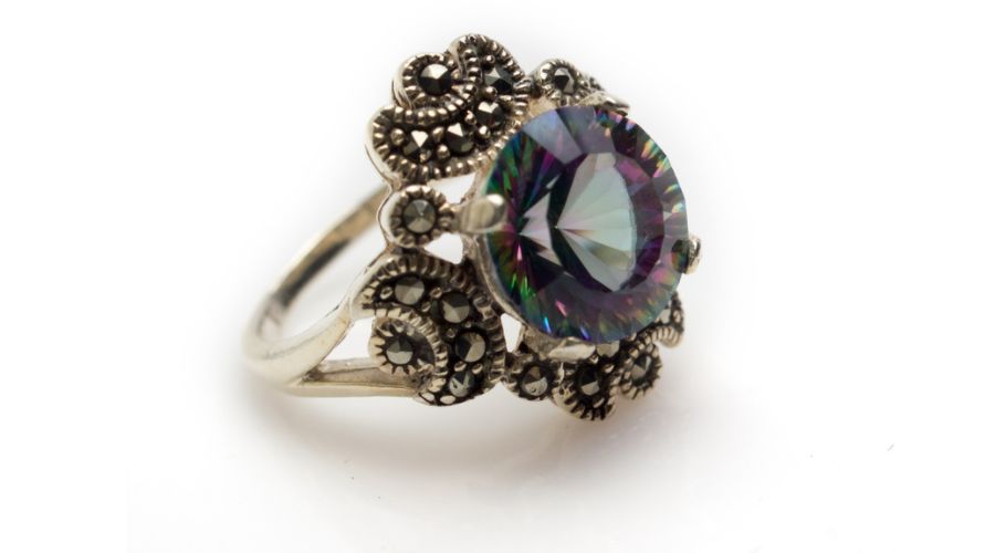 A vintage marcasite ring with a large central gemstone isolated on a white background