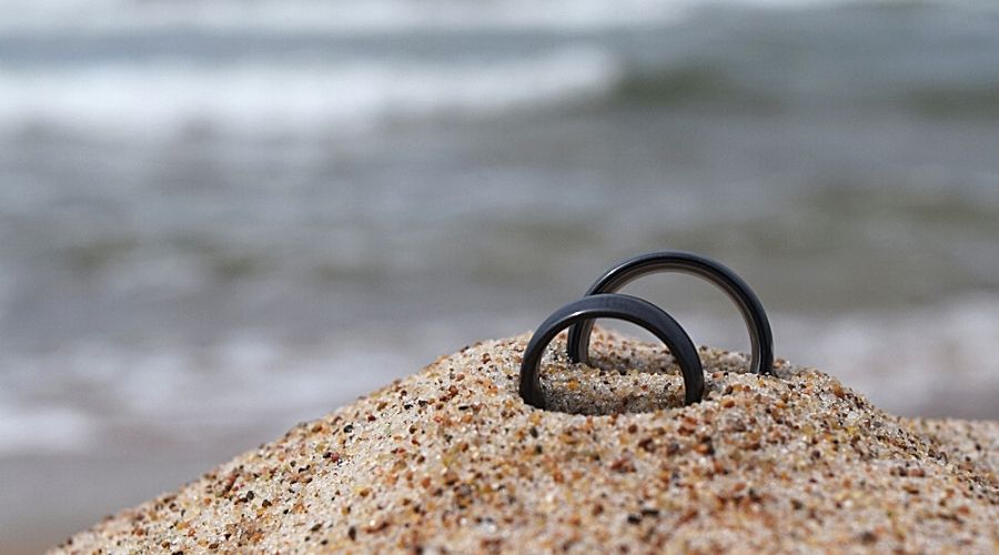 black gold wedding rings on the sand