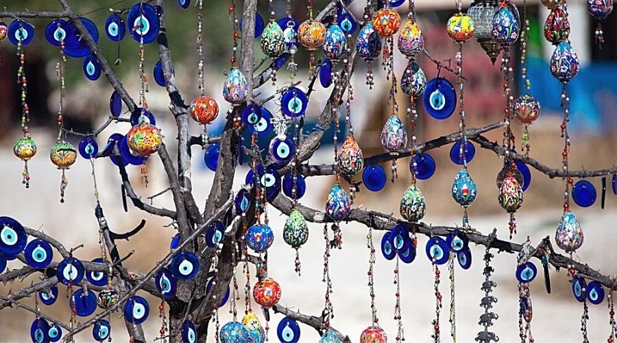 branches of old tree decorated with evil eye amulets