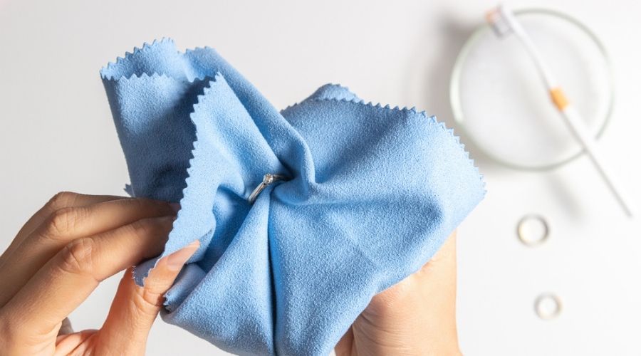 Overhead shot of somebody cleaning a palladium ring with a blue cloth