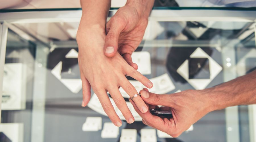 cropped image of a couple choosing a diamond wedding ring in the shopping mall