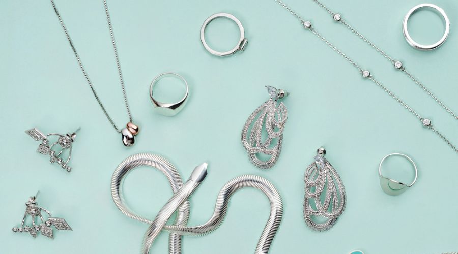 different silver colored jewelry on minimalist mint green background