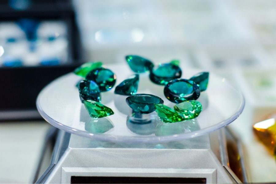 Several green topaz stones on a jewelry stand